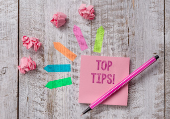 Conceptual hand writing showing Top Tips. Concept meaning small but particularly useful piece of practical advice Note paper and line arrow stickers on the top of wooden table desk