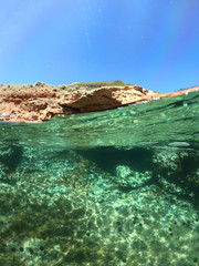 Wall Mural - Underwater photo of tropical cave with emerald clear sea and coral reef