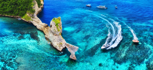 Wall Mural - fast boat at the sea in bali, indonesia. aerial view of luxury floating boat on transparent turquois