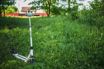 White electric scooter on the field of nature. ecological type of transport