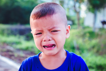 Asian boy crying on the street