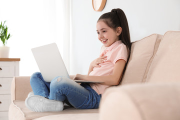 Poster - Little girl using video chat on laptop at home