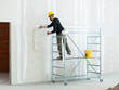 © Antonio Gravante - worker plastering gypsum board wall.