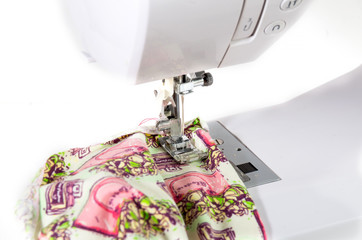 Sewing machine with fabric on white background closeup