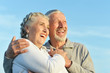 © aletia2011 - Portrait of happy senior couple hugging against blue sky