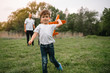 © Serhii - Father, mother and son playing with toy airplane in the park. friendly family. People having fun outdoors. Picture made on the background of the park and blue sky. concept of a happy family.