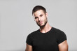 © KDdesignphoto - Muscular model young man with beard in black t-shirt on gray background. Fashion portrait of brutal sporty sexy strong muscle guy with modern trendy hairstyle. Model, fashion concept.