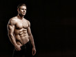 © KDdesignphoto - Muscular model young man on dark background. Fashion portrait of strong brutal guy with trendy hairstyle. Sexy naked torso, six pack abs. Male flexing his muscles. Sport workout bodybuilding concept.