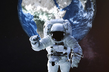 Wall Mural - astronaut in a front of earth planet of solar system. science fiction. elements of the image were fu