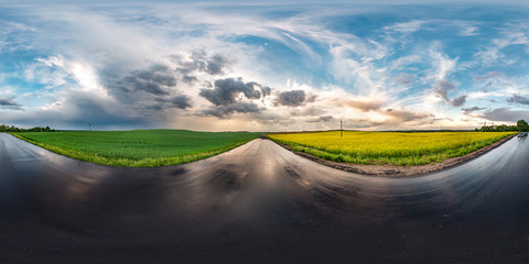 Wall Mural - full seamless spherical hdri panorama 360 degrees angle view on wet asphalt road among canola fields in evening sunset after storm with awesome clouds in equirectangular projection,  VR AR content
