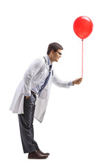 Poster - Male doctor giving a red balloon