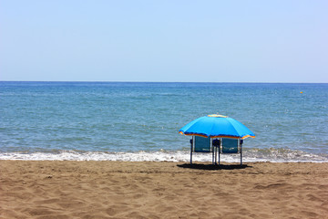 Beach umbrella and two chairs on a perfect beach to enjoy the holidays on a sunny day