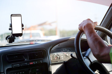 Wall Mural - cropped shot view the driver uses the phone while driving. modern smart phone with round edges. isol