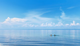 Fototapeta Na sufit - Lake Baikal on summer day. Two girls swimming in the blue water of the lake. White clouds are beautifully reflected in the water. Natural background. The concept of outdoor recreation, tourism, travel
