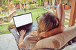 © astrosystem - Girl using laptop on a home porch / terrace.