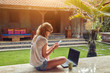 © astrosystem - Freelancer girl with smartphone, coffee / tea and laptop on a home porch.