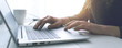 © StockPhotoPro - Woman sitting at desk and connecting with her laptop, she is working and typing on the keyboard, hands close up