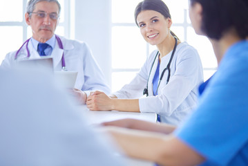 Serious medical team discussing patient's case in a bright office