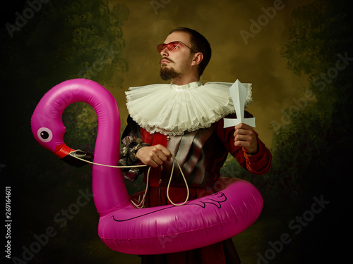 Photographie Young man as a medieval knight on dark background