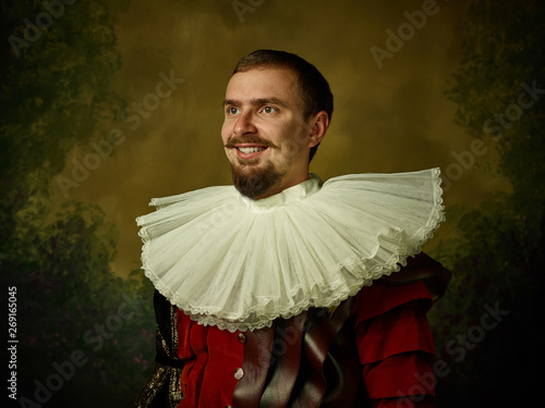 Fotomural Young man as a medieval knight on dark studio background