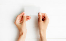 Woman Holding White Business Card In Hands. Tamplate For Your Design.
