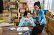© PR Image Factory - business coworkers woman fighting happy to online shopping working with laptop and box package in home office. real moment young girls employees in warehouse. two colleagues having discussion on pad