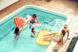 © Alessandro Biascioli - Happy friends having fun in swimming pool  during summer vacation - Young people relaxing and floating on air lilos in the pool resort - Friendship, holidays and youth lifestyle concept