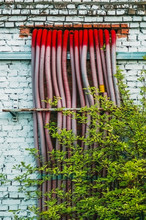 Red Corrugated Pipes Coming Out Of A White Brick Wall