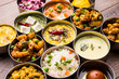 assorted Indian/Pakistani food in stainless steel bowls creating pattern or design, selective focus