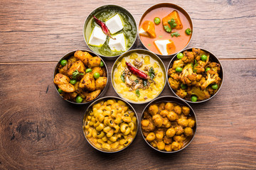 Canvas Print - assorted Indian/Pakistani food in stainless steel bowls creating pattern or design, selective focus