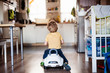 © Halfpoint - A rear view of a toddler boy with toy car playing at home.