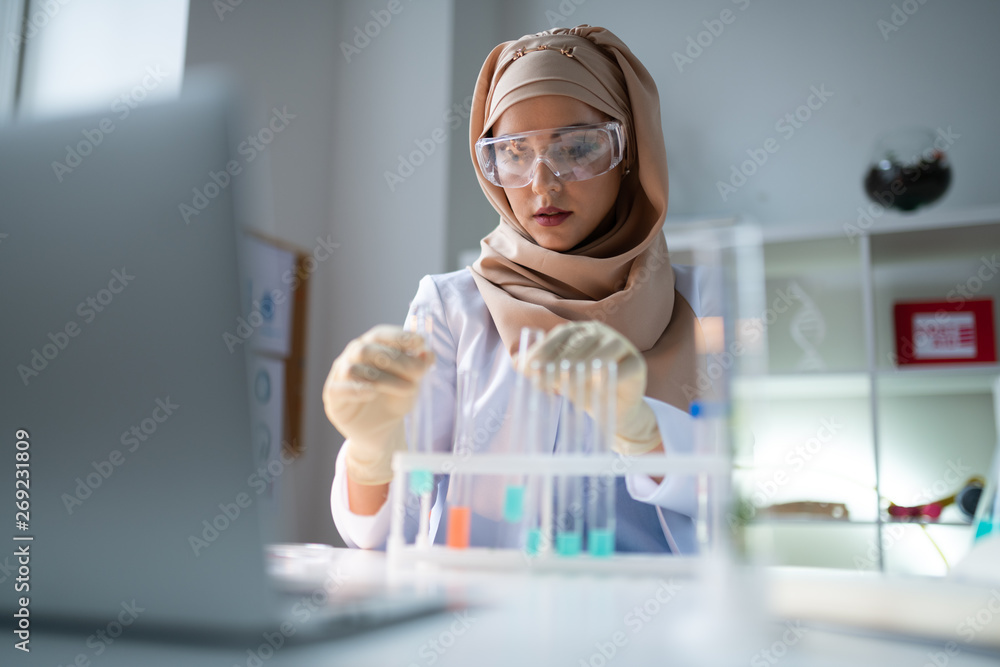 Young chemist wearing hijab working in laboratory Stock Photo | Adobe Stock