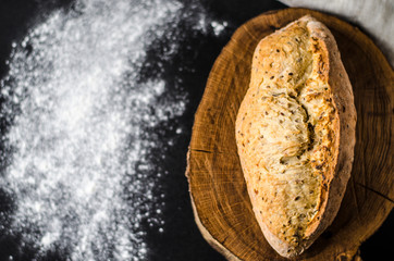 Freshly baked homemade traditional bread on rustic wooden table, top view