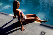 © BGStock72 - Attractive young woman in bikini sits by the poolside and enjoys the summer sun