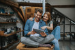 © BGStock72 - Young couple is using a digital tablet and smiling in kitchen at home