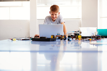 Wall Mural - Male Student Building And Programing Robot Vehicle In School Computer Coding Class