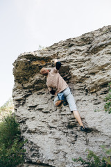 Brave young man climbs the cliff