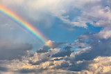 Fototapeta Tęcza - Rainbow in the spring cloudy sky after a thunderstorm.