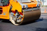 Fototapeta Miasto - Repair of roads.  Laying asphalt using a roller.
