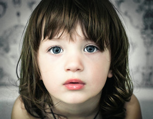 Little girl in an urban setting smiles at the camera.