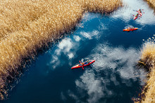 Group Of People In Kayaks Among Reeds On The Autumn River.