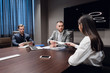 © romankosolapov - Startup business, creative business people of different age and races gather in meeting room in dark modern office interior, vivously discussing