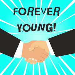 Writing note showing Forever Young. Business concept for mindset of a being fresh and carefree no matter the age Hand Shake Multiracial Male Business Partners Formal Suits