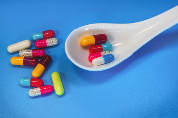 medical capsules in a porcelain spoon.