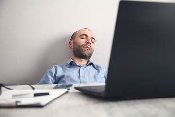 Wall Mural - Caucasian tired businessman at office desk.