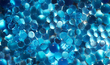 Water Blue Gel Balls. Polymer Gel. Silica Gel. Balls Of Blue Hydrogel. Crystal Liquid Ball With Reflection. Texture Background. Close Up Macro