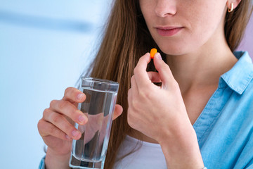 Wall Mural - Medicine young woman taking pills and vitamins for wellness and treatment disasses. Dietary supplement and health care.