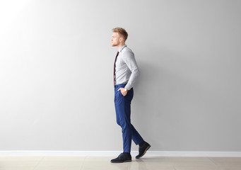 Wall Mural - Fashionable young man near grey wall