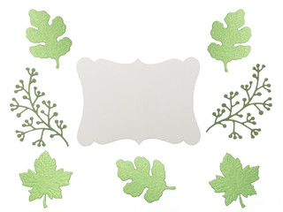 Wall Mural - Green leaves and branches with grey copy space on white background. Greeting card concept