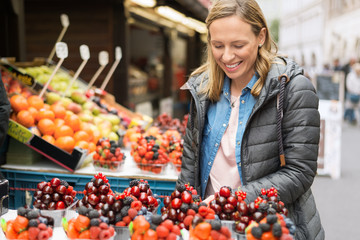 Young happy woman buying fruit at the farmer's market.